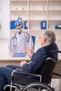 Old patient in wheel-chair visiting devil doctor Royalty Free Stock Photo