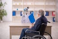 Old patient in wheel-chair visiting devil doctor