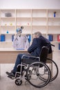 Old patient in wheel-chair visiting devil doctor