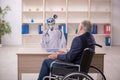 Old patient in wheel-chair visiting devil doctor Royalty Free Stock Photo