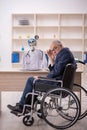 Old patient in wheel-chair visiting devil doctor