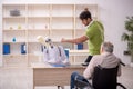 Old patient in wheel-chair visiting skeleton doctor Royalty Free Stock Photo