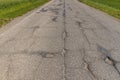 An old paved road with a lot of holes and damage Royalty Free Stock Photo