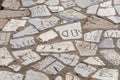 Old pavement made of marble pieces with latin letters