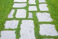 Old paving in a public park made with irregularly shaped stone blocks in a pedestrian zone and fresh green lawn Royalty Free Stock Photo