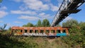 An old pedestrian bridge over the railway and an old rusty broken wagon Royalty Free Stock Photo