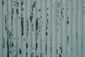 Old peeling white paint in messy pattern on corrugated metal wall surface Royalty Free Stock Photo