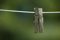 Old pegs on a clothesline outdoors against a blurred background with copy space. Details of two weathered wooden Royalty Free Stock Photo