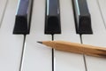 Old Pencil on White Keys of Electric Piano in Crosswise View