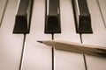 Old Pencil on White Keys of Electric Piano in Crosswise View and Vintage Tone