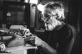 Old pensive man seating in shed making clay pottery Royalty Free Stock Photo