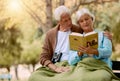 Old, people and book with a mature couple reading in the park for knowledge and education. Bonding, read and love with a Royalty Free Stock Photo