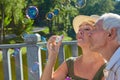 Old people with bubble blower. Royalty Free Stock Photo