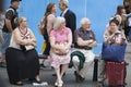 Old people in glasses sitting on bench in street. Have a little break