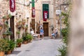 Old people with masks converse in the historic alley Royalty Free Stock Photo