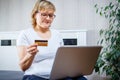 Old people and modern technology concept. Portrait of a 50s mature woman hand holding credit card, using online internet payment Royalty Free Stock Photo