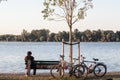 old people, retired couple, old man and woman, having a break sitting and sleeping on a bench after biking with bicycles by Danube