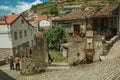 Old people walking down the alley on slope next to stone wall Royalty Free Stock Photo