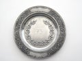 Old pewter dish with number 75 and oak and lily ornament Royalty Free Stock Photo