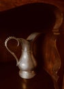 Old pewter pitcher on shelf. S curves & shadows with text space in dark area is available. Royalty Free Stock Photo