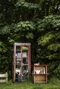 An old phone booth and some small shelfs on wadden sea island Texel in the Netherlands Royalty Free Stock Photo