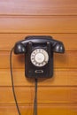 Old phone with dialer disk on wooden background