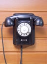 Old phone with dialer disk on wooden background