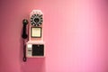 Old phone hanging on a pink wall Royalty Free Stock Photo