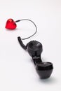 Old phone reciever and cord connection with red heart. Royalty Free Stock Photo