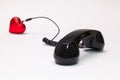 Old phone reciever and cord connection with red heart. Royalty Free Stock Photo