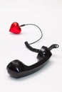 Old phone reciever and cord connection with red heart. Royalty Free Stock Photo