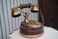 An old phone stands on a vintage table, close-up