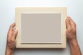 Old photo in frame in the hands of man. Empty template for picture, mock-up. Gray background. Royalty Free Stock Photo