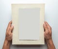 Old photo in frame in the hands of man. Empty template for picture, mock-up. Gray background Royalty Free Stock Photo