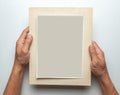 Old photo in frame in the hands of man. Empty template for picture, mock-up. Gray background. Royalty Free Stock Photo