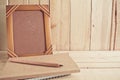 Old photo frame , notebook and pencil on wooden table Royalty Free Stock Photo