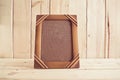 Old photo frame on wooden table over wood background Royalty Free Stock Photo