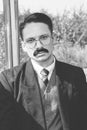 old photo of man in suit with a mustache and glasses on the train Royalty Free Stock Photo