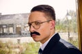 Old photo of serious man in suit with a mustache and glasses on Royalty Free Stock Photo