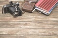 Old photocamera with leather case, notebooks on vintage wood background Royalty Free Stock Photo