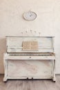 An old piano with a candlestick and clock