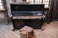 An old piano in a dirty room of an abandoned house. Black piano with white keys covered in dirt Royalty Free Stock Photo