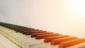 Old piano keyboard in sunbeams of orange hue light, black and white piano keys and there is a place for an inscription, white Royalty Free Stock Photo