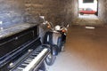 An old piano with a retro moped in the archway of the house on a sunny day Royalty Free Stock Photo