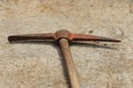Old pickaxe with wooden handle kept in concrete floor