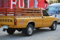 Old pickup truck, orange color, vintage style, has a beautiful wooden side stall, outdoor park