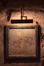 Old picture frame with lamp illumination in a dark room, with old walls. You can put copy space in the picture frame Royalty Free Stock Photo