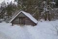 An old picturesque outbuilding near the forest in the village in winter