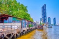 The old pier with covered market on Chao Phraya river and modern highrises on background, Bangkok, Thailand Royalty Free Stock Photo