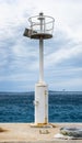 Old pier with a lighthouse beacon and calm sea. Royalty Free Stock Photo